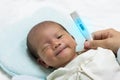 Asian cute new born baby check temperature with digital thermometer. Royalty Free Stock Photo