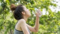 Asian cute sport healthy fit and firm slim teen girl drink water from plastic bottle on the hand in summer hot day at outdoor Royalty Free Stock Photo