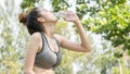 Asian cute sport healthy fit and firm slim teen girl drink water from plastic bottle on the hand in summer hot day at outdoor Royalty Free Stock Photo