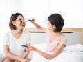 Asian cute two girl test pink blush on cheek from makeup palette in the morning at home before go to shopping mall