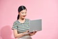 Asian cute young woman smiling standing using laptop computer on hand looking to computer isolated Royalty Free Stock Photo