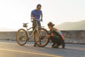 Asian cyclist couple assembles bikes for a morning bike ride by the lake
