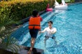 An asian dad take a vacation with his family in the pool, preparing to catch his son who will jump into the water