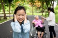 Asian daughter closed ears with hands, little child girl did not want to hear parents,grandmother in wheelchair and mother arguing Royalty Free Stock Photo