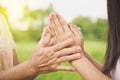 Asian daughter greeting or pay respect to her mother, two hands holding each others Royalty Free Stock Photo