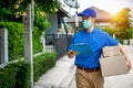 Asian delivery man in blue t-shirt carrying parcel box
