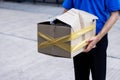 Asian delivery man in blue uniform he emotional falling courier courier showing damaged box, cheap parcel delivery, poor shipment Royalty Free Stock Photo