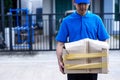 Asian delivery man in blue uniform he emotional falling courier courier showing damaged box, cheap parcel delivery, poor shipment Royalty Free Stock Photo