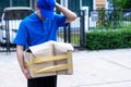 Asian delivery man in blue uniform he emotional falling courier courier showing damaged box, cheap parcel delivery, poor shipment Royalty Free Stock Photo