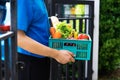 Asian delivery man blue uniform wearing medical face mask making grocery service giving fresh food Royalty Free Stock Photo