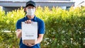 Asian delivery man holding grocery bag and food delivery bill to sending product to customer