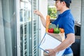 Asian delivery man holding grocery bag of food, fruit, vegetable and  invoice clipboard during knocking Royalty Free Stock Photo