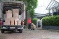 Asian delivery man in red uniform delivering parcel boxes to woman recipient at home Royalty Free Stock Photo