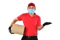 Asian delivery man wearing face mask and gloves in red uniform delivering parcel box isolated on white background during COVID-19 Royalty Free Stock Photo