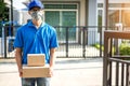 Asian delivery man wearing mask delivers parcel, customer