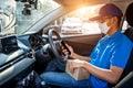 Asian delivery man wearing mask protect covid-19 virus and stocktaking checklist Royalty Free Stock Photo