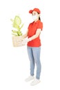 Asian Delivery woman in red uniform isolated on white background.Courier in protective mask and medical gloves delivers plant.