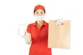 Asian Delivery woman in red uniform isolated on white background.Courier in protective mask and medical gloves delivers takeaway