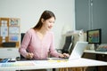 Asian designer using digital pen and laptop in a creative office, showcasing professional work, innovation Royalty Free Stock Photo