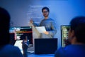asian developer leads present code review session, pointing at code projected on the wall with colleagues teamwork and knowledge