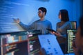 asian developer leads present code review session, pointing at code projected on the wall with colleagues teamwork and knowledge