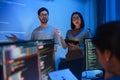 asian developer leads present code review session, pointing at code projected on the wall with colleagues teamwork and knowledge