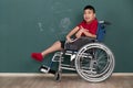 Asian disabled boy on wheelchair showing his painting on wall with happy and proud. Idea for learning ability of handicapped kid Royalty Free Stock Photo