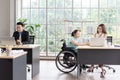 Asian disabled businesswoman woking together with colleague at workplace Royalty Free Stock Photo