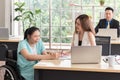 Asian disabled businesswoman in wheelchair working together with a colleague in the office Royalty Free Stock Photo