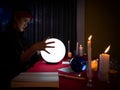 Asian diviner girl use crystal lamp light ball and predict destiny, business, health and wealth in the future life with candles