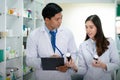 Asian Doctor and Asian Pharmacist girl discust abour type of medicine in Hospital