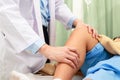 An Asian doctor checks the knees of an obese patient lying on a nursing bed. Royalty Free Stock Photo