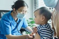 Asian doctor examining and listening lungs of little baby boy with stethoscope Royalty Free Stock Photo