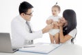 Asian doctor examining a little girl by stethoscope Royalty Free Stock Photo