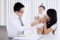 Asian doctor examining a little girl by stethoscope Royalty Free Stock Photo