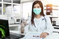 Asian doctor holds a syringe, blood sample test tube for covid-19 analyzing with patient file on desk in lab. laboratory analyzing