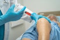 Asian doctor inject Hyaluronic acid platelet rich plasma into the knee of senior woman to walk without pain