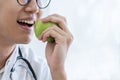 Asian doctor men Eating fruit Which is green apple that he held in his hand with white background Royalty Free Stock Photo