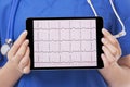 Asian doctor or nurse holding tablet computer showing an EKG Royalty Free Stock Photo