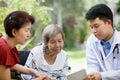 Asian doctor talking with elderly female patient. Royalty Free Stock Photo