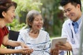 Asian doctor talking with elderly female patient. Royalty Free Stock Photo