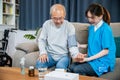 Asian doctor woman examine do checking old man client heart rate with pulsimeter Royalty Free Stock Photo