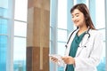 Asian Doctor woman with stethoscope using a tablet