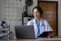 Asian doctor working with laptop in hospital and medical stethoscope, medicine on clipboard on workplace. Royalty Free Stock Photo