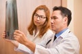 Asian doctors examining x-ray film of a patient. Royalty Free Stock Photo