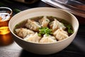 asian dumpling soup in a clear broth served in a bowl