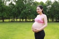 Asian Eastern Chinese happy pregnant woman in yoga dress hands hold her belly expecting baby to born parents mother love concept Royalty Free Stock Photo