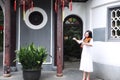 Asian Eastern Chinese young artist player woman play violin perform music garden nature outdoor ancient building red lantern