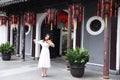 Asian Eastern Chinese young artist player woman play violin perform music garden nature outdoor ancient building red lantern