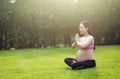 Asian Eastern Chinese young pretty pregnant girl woman do yoga sit in meditation, do lotus gesture of yoga over sunset,namaste Royalty Free Stock Photo